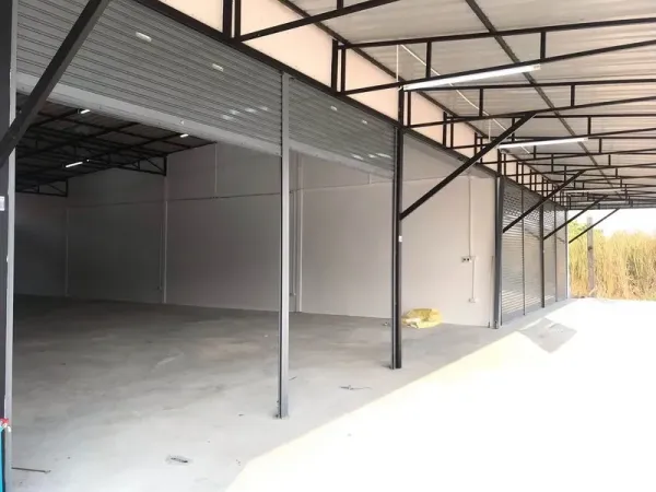 货栈 出租在Lam Luk Ka, Pathum Thani - 外部装卸区，多个开启的卷帘门，金属雨棚下拥有宽阔车道。