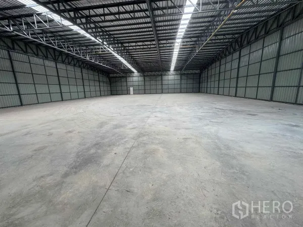 Warehouse for rent in Pak Kret, Nonthaburi - Open-plan warehouse hall showing clear-span space and natural light from roof skylights.