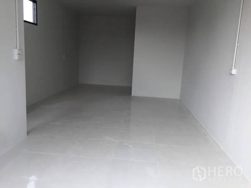 Warehouse for sale in Khlong Luang, Pathum Thani - Ground-floor tiled multipurpose room with window and white walls.