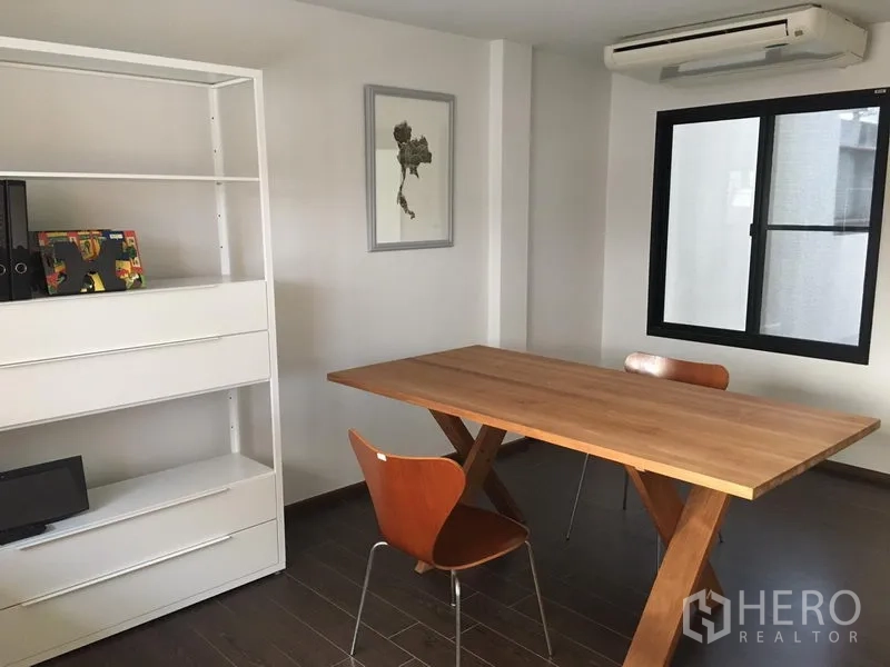 联排别墅 出租在Khlong Toei, Bangkok - 明亮的多功能房，木桌、置物架与空调。