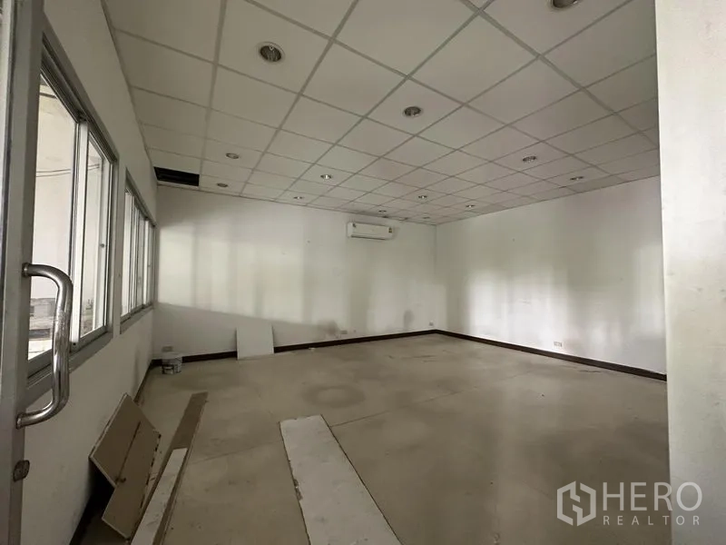 Warehouse for rent in Lat Krabang, Bangkok - Internal office room with drop ceiling, air‑conditioning unit and windows overlooking the warehouse.