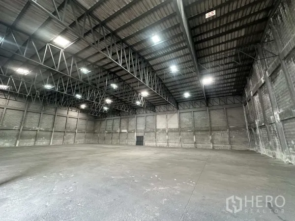 Warehouse for rent in Phra Nakhon Si Ayutthaya - Wide interior view showing steel beams and bright overhead lighting.