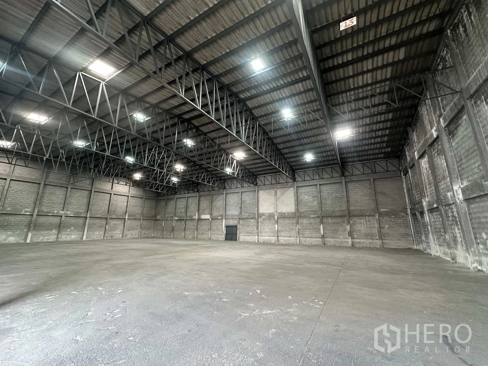 Warehouse for rent in Phra Nakhon Si Ayutthaya - Wide interior view showing steel beams and bright overhead lighting.