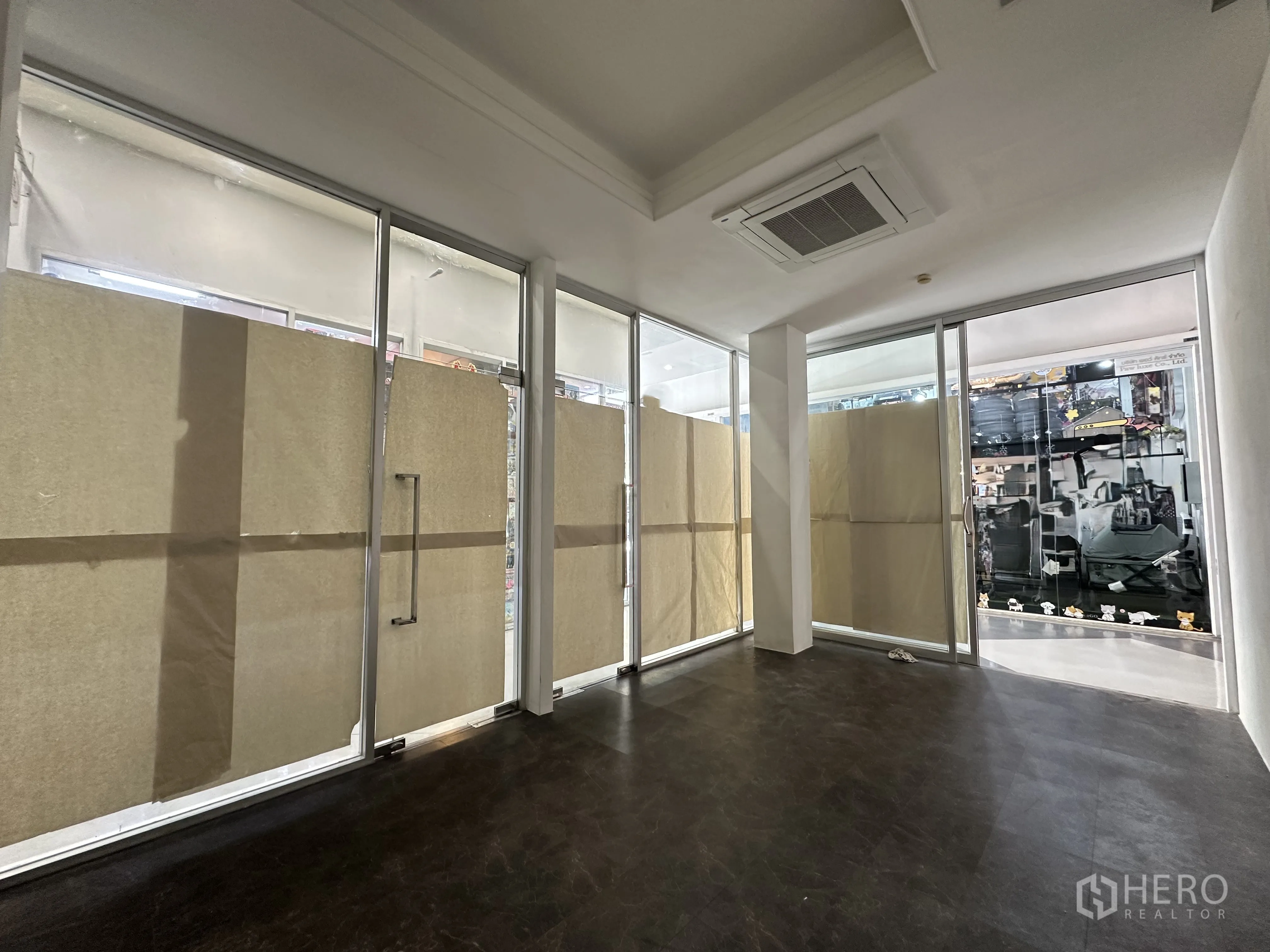 Retail Space for rent in Khlong Toei, Bangkok - Open-plan retail unit with floor-to-ceiling glass storefront, dark flooring, and ceiling cassette air-conditioning.