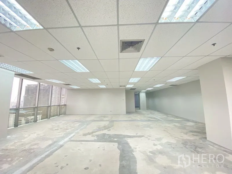 Office Space for rent in Chatuchak, Bangkok - Bright open-plan office with suspended ceiling lights, bare concrete floor and city views through large windows.