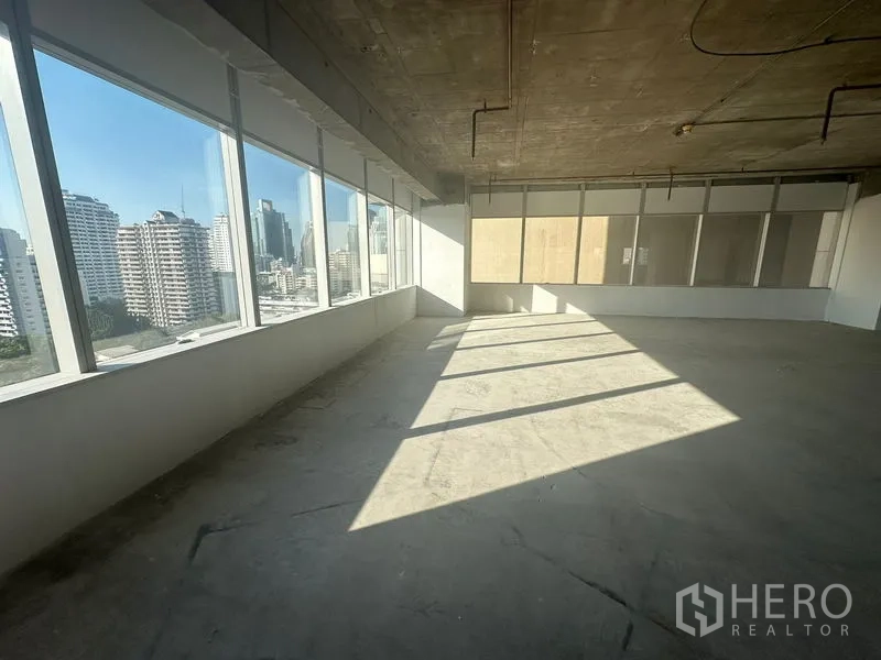 办公空间 出租在Watthana, Bangkok - 明亮转角区域，通高玻璃俯瞰城市景观。