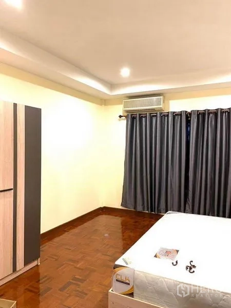 Townhouse for rent in Bang Na, Bangkok - Spacious master bedroom with parquet floor, air-conditioning, curtains and wardrobe.
