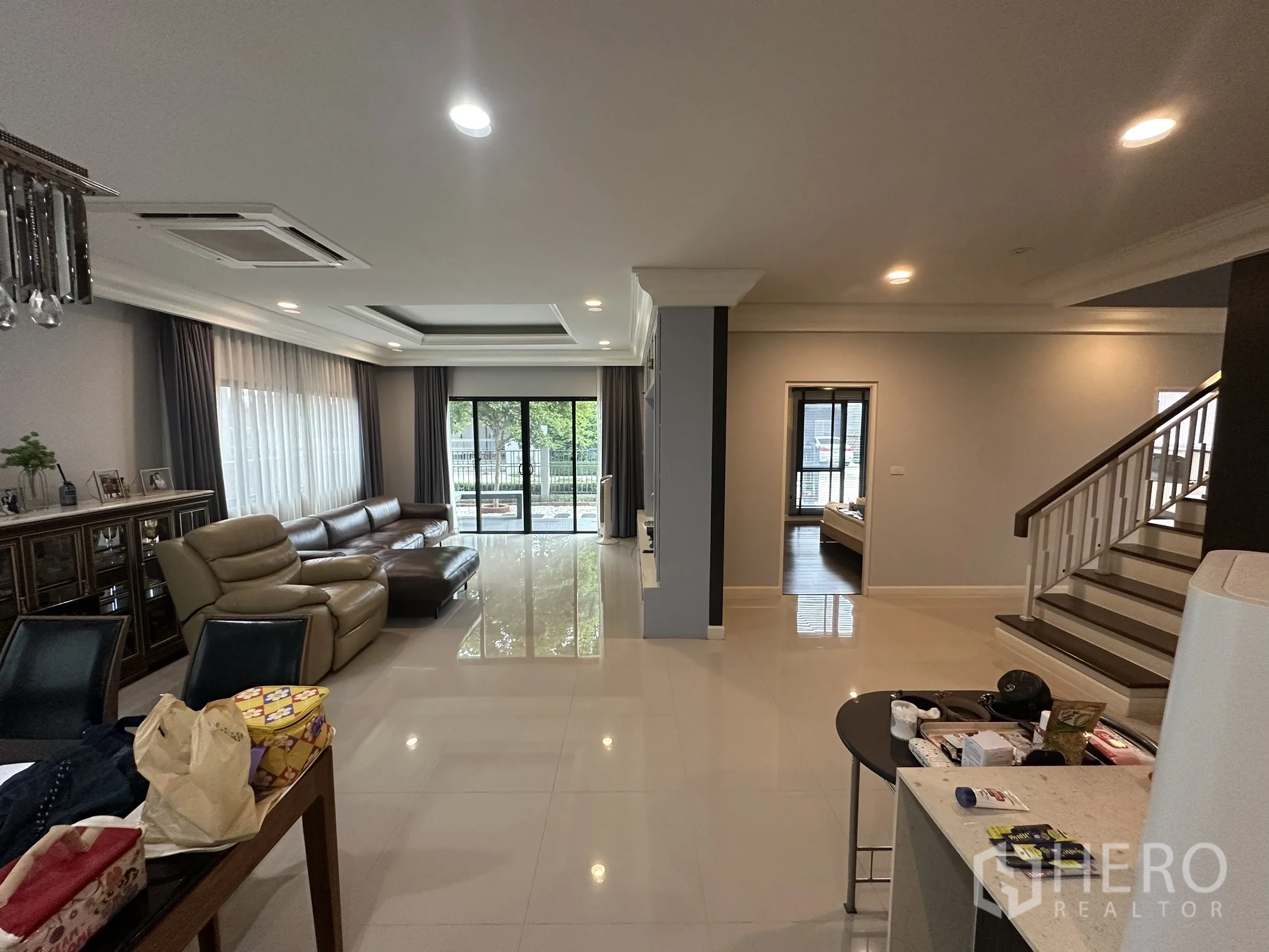 Detached House for rent in Lam Luk Ka, Pathum Thani - Wide living room with large windows, sliding doors and staircase.