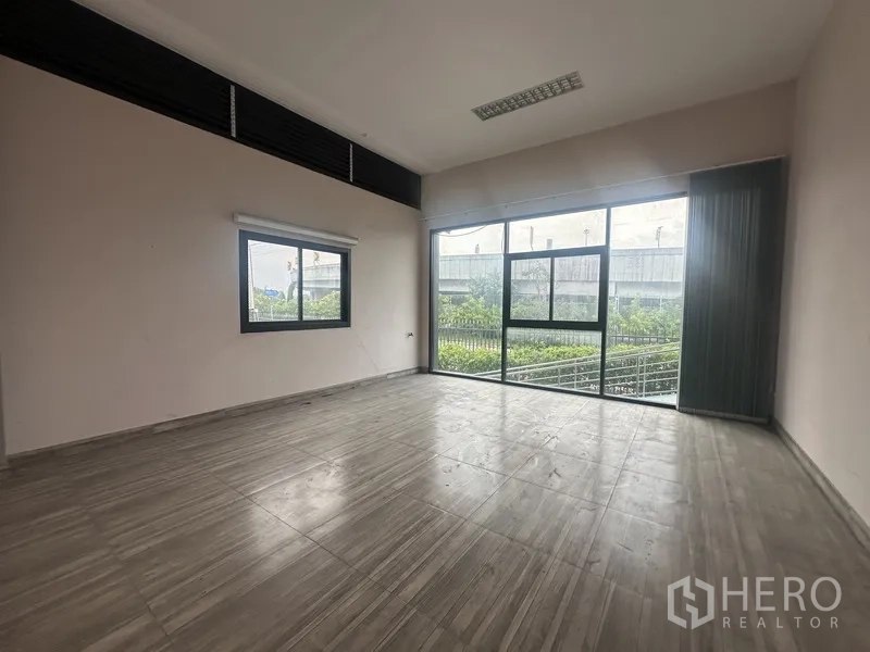 Standalone for rent in Prawet, Bangkok - Bright room with large corner windows and a garden outlook.