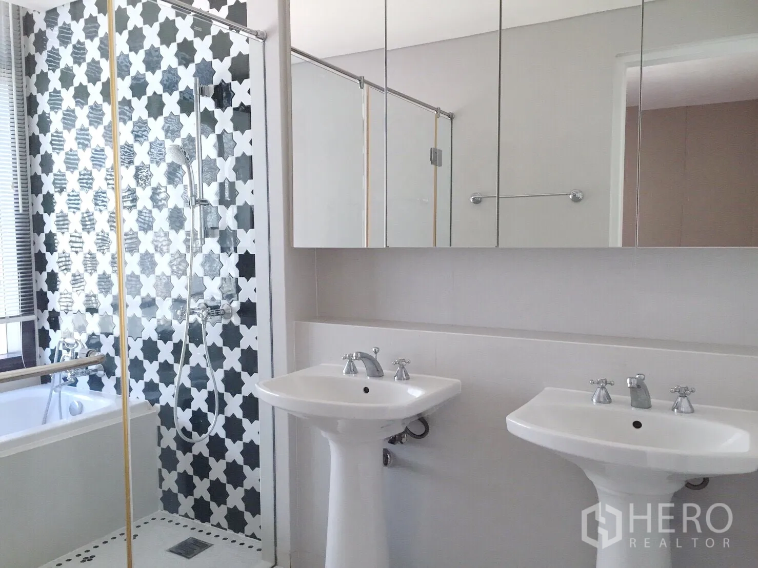 Condominium for rent in Khlong Toei, Bangkok - Master bath with twin basins, glass shower, black-and-white tiled wall and bathtub