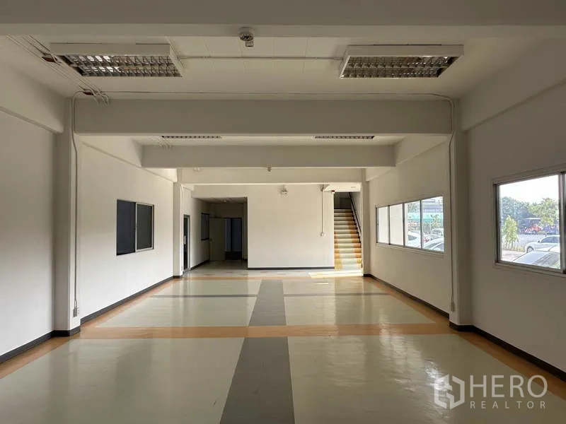 Factory for rent in Bang Phli, Samut Prakan - Open-plan office hall with staircase to the upper floor and abundant natural light.