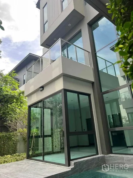 独立式住宅 出售在Bang Kruai, Nonthaburi - 现代多层外立面，玻璃墙与阳台，旁有泳池