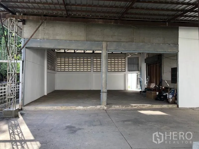 Warehouse for rent in Khlong Sam Wa, Bangkok - Secondary storage bay with concrete floor and roof cover beside the main warehouse.