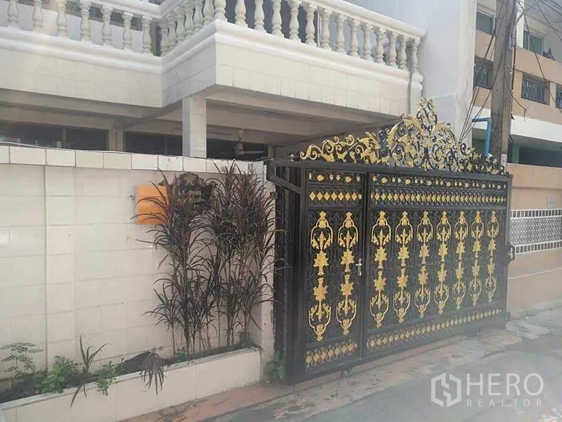 Townhouse for rent - Townhouse exterior with ornate black-and-gold gate and white balustrade balcony.