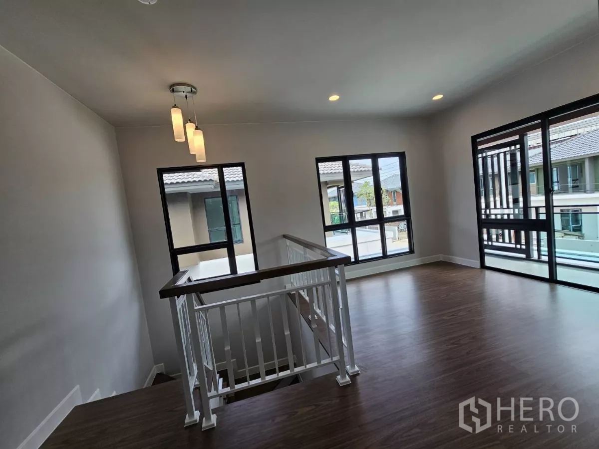 Detached House for sale in Lam Luk Ka, Pathum Thani - Upstairs family lounge with pendant lights and large windows.