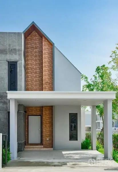 Detached House for sale in Lam Luk Ka, Pathum Thani - Close-up of the brick feature wall and main entrance under a pitched roof of the modern home.