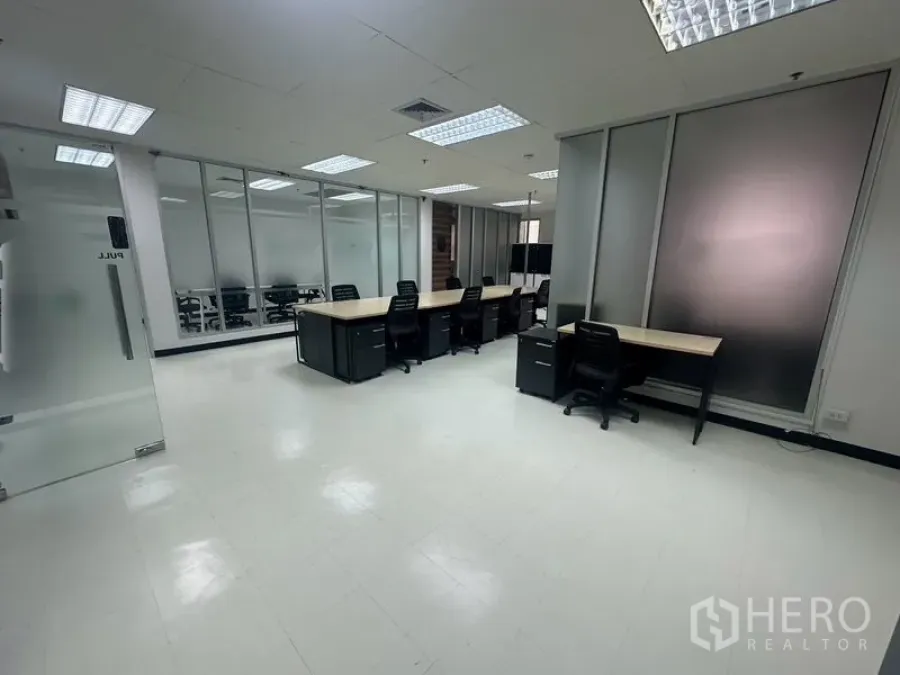 Office Space for rent - Open office space showcasing rows of workstations and frosted glass partitions.