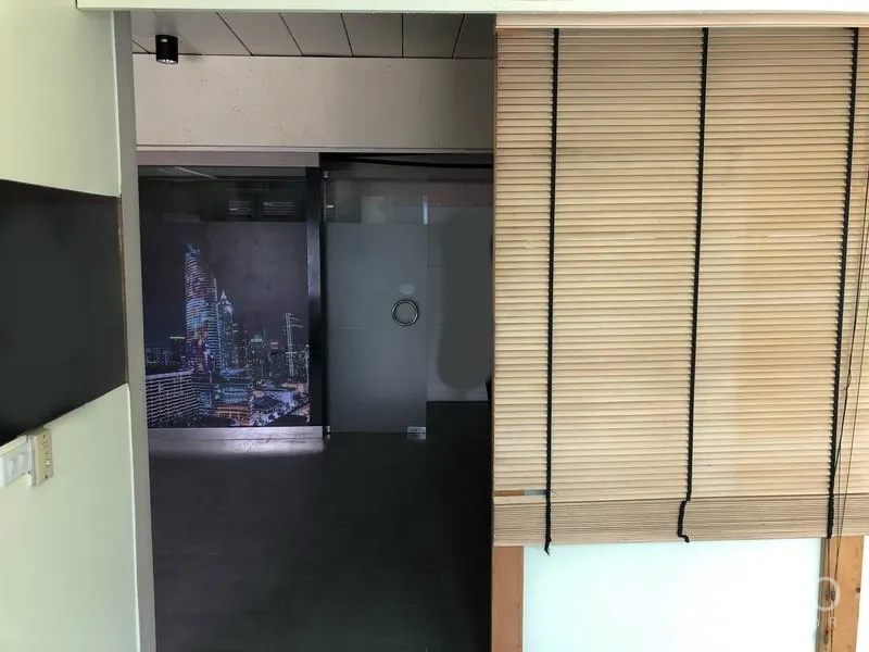 Home Office for rent or sale in Huai Khwang, Bangkok - Small office zone with window blinds and frosted glass door beside a cityscape feature wall.