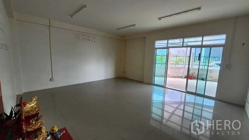 Factory for rent in Samut Sakhon - Open-plan office area facing sliding glass doors to the front yard.