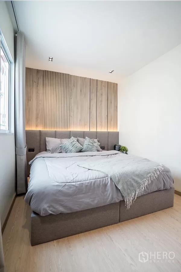 Detached House for rent in Huai Khwang, Bangkok - Master bedroom view with large window, curtains and bedside table.