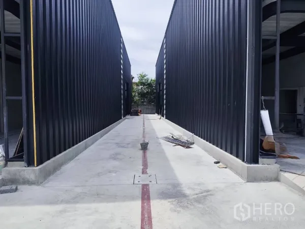 Warehouse for rent in Sai Mai, Bangkok - Central driveway between two warehouse blocks with a smooth concrete surface.