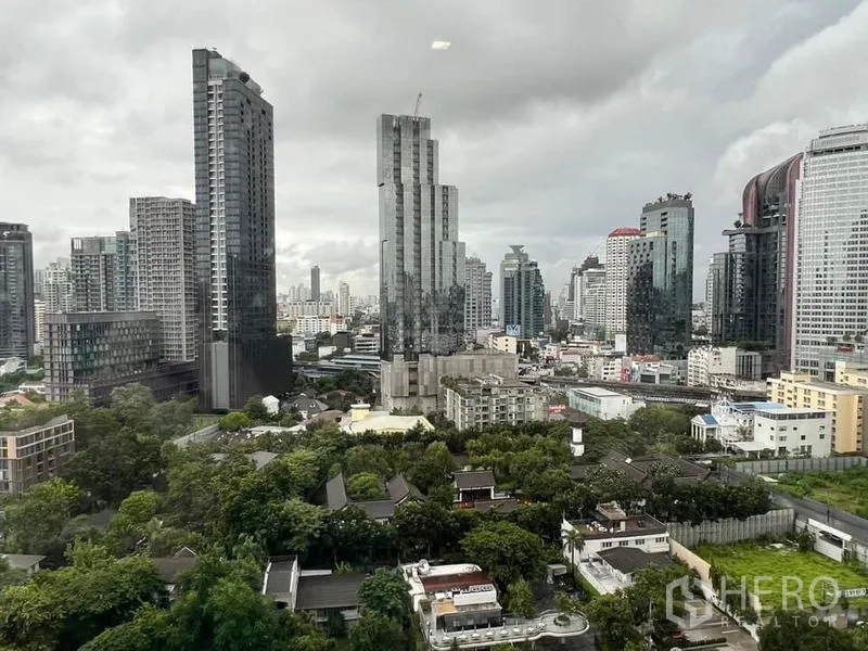 Condominium for rent - High‑floor city skyline view with towers and green spaces near Thonglor BTS area.