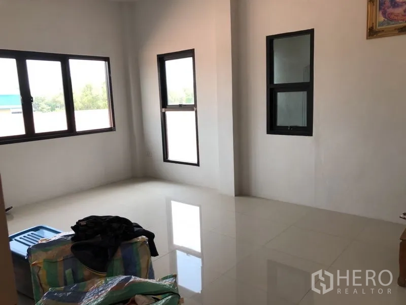 Detached House for sale in Lam Luk Ka, Pathum Thani - Empty bright room with multiple windows and tile floor.