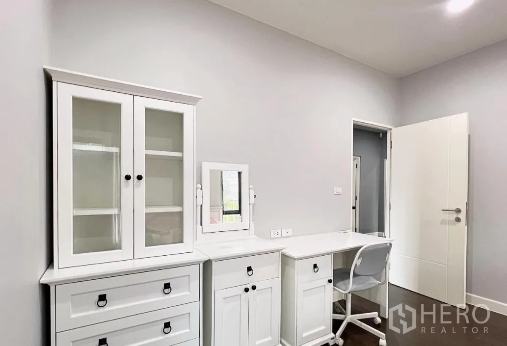 Detached House for rent or sale in Lam Luk Ka, Pathum Thani - Secondary bedroom with white built-in cabinets, vanity and study desk.