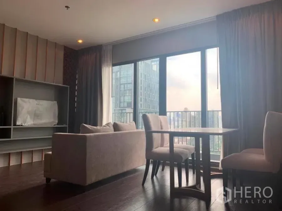 Condominium for rent in Watthana, Bangkok - Bright living and dining area with sofa, table and floor-to-ceiling windows showcasing Ekkamai city views.