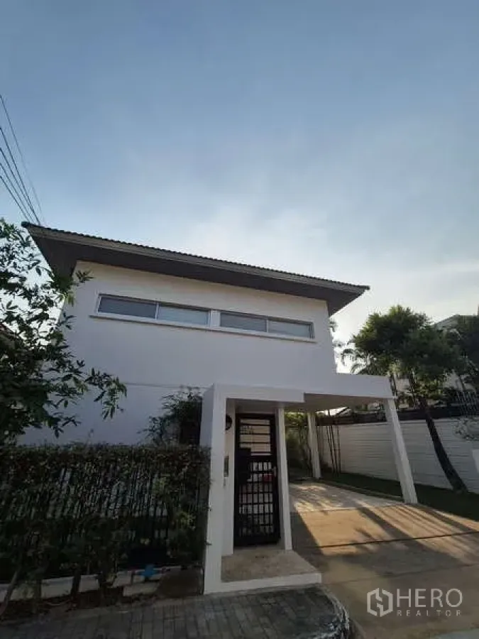 Detached House for rent in Bang Kruai, Nonthaburi - Modern two-storey white detached house with carport and gated entry.