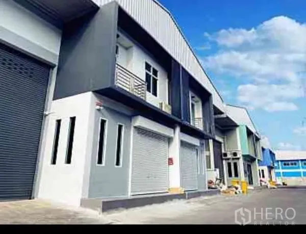 工厂 出租在Mueang Samut Sakhon, Samut Sakhon - 现代工厂排屋外立面，配卷帘大门与宽阔装卸车道，位于Mueang Samut Sakhon。