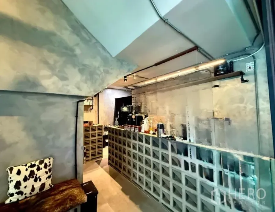 零售空间 出租在Khlong Toei, Bangkok - 工业风咖啡吧台，混凝土格栅柜台、咖啡设备与外露管线的精致小店内景。
