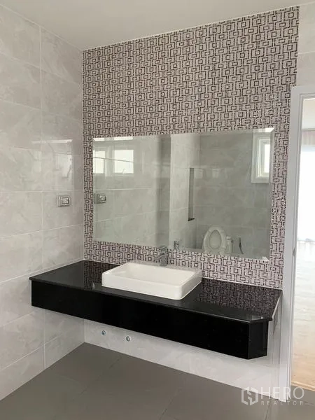 Townhouse for rent in Bang Na, Bangkok - Bathroom vanity with large mirror, patterned backsplash and countertop sink