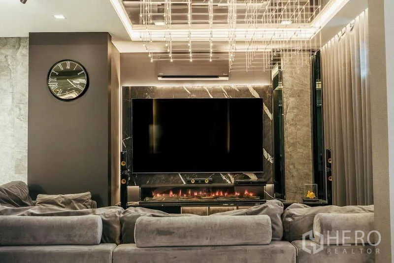 Detached House for sale in Sai Mai, Bangkok - Sophisticated living room with oversized TV on a marble media wall and linear fireplace.