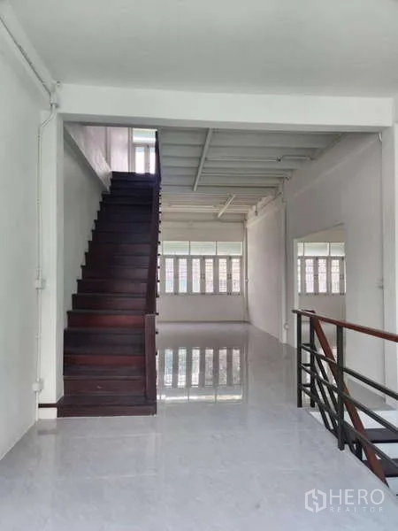Shophouse for rent in Khlong Toei, Bangkok - Wood staircase leading to upper floors in freshly painted interior.