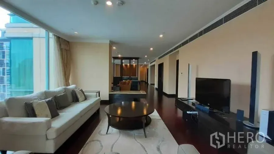 Condominium for rent in Pathum Wan, Bangkok - Spacious living room with sofa set, TV console and floor-to-ceiling windows
