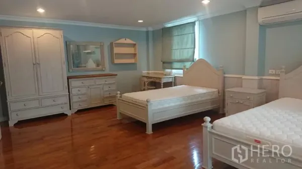 Detached House for rent in Mueang Samut Prakan, Samut Prakan - Spacious bedroom with twin beds, wardrobes, dresser and polished wooden flooring.