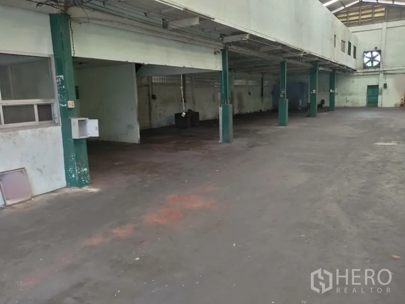 Factory for rent in Saphan Sung, Bangkok - Spacious factory interior with high ceiling, columns, and ventilation fan.