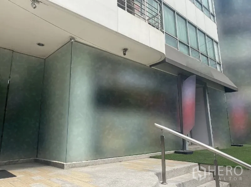 Retail Space for rent in Watthana, Bangkok - Street-facing shopfront with large opaque glass panels, canopy, CCTV cameras, and steps to the door.