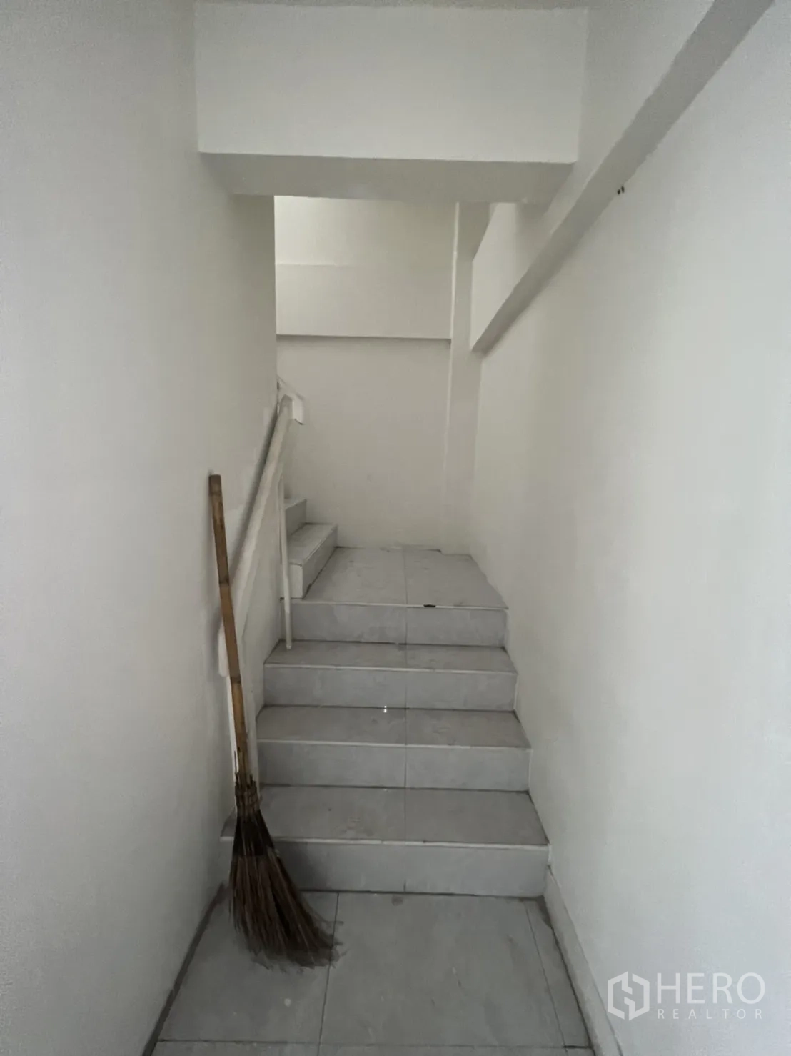 Shophouse for rent in Watthana, Bangkok - Internal staircase with white handrail leading up to the higher floors.