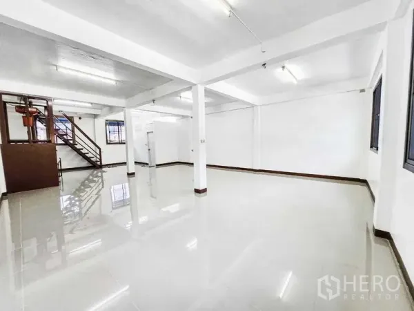 Home Office for rent in Khlong Toei, Bangkok - Bright open-plan floor with glossy tiles, columns, windows and a side staircase.