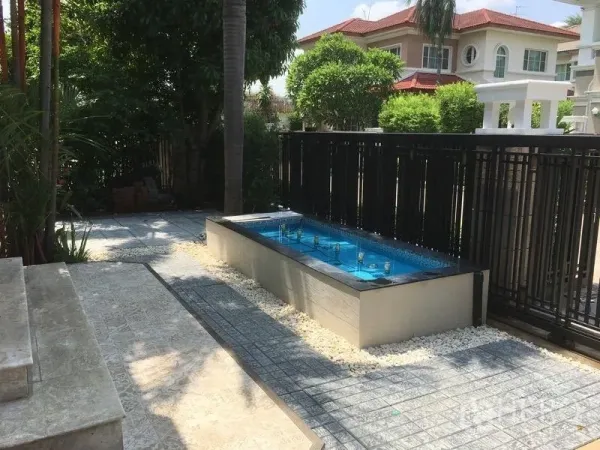 Detached House for rent - Landscaped front courtyard featuring a rectangular fountain beside a black metal fence and tiled walkway under mature trees.