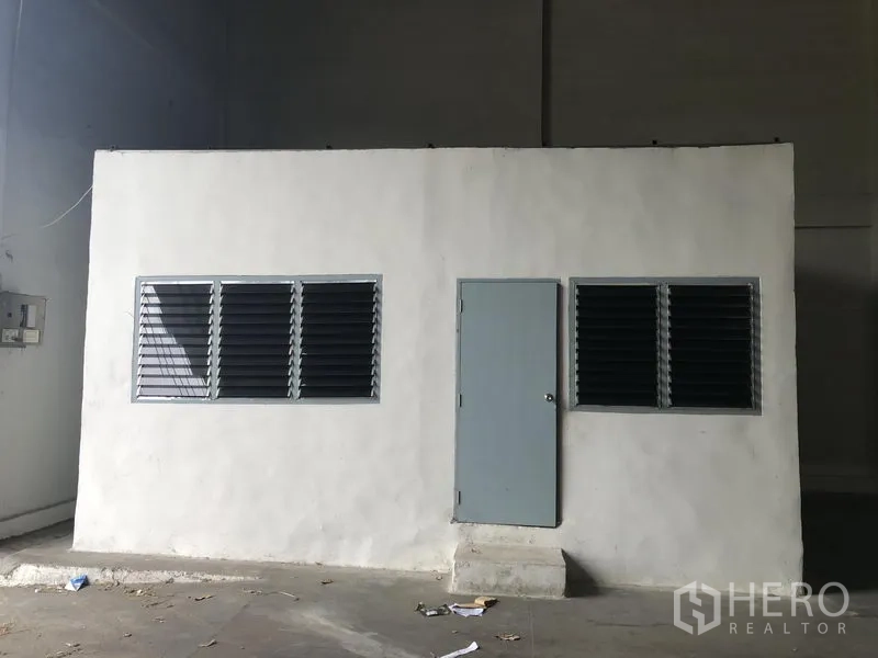Warehouse for rent in Khlong Luang, Pathum Thani - Small built-in office room with louvered windows inside the warehouse.