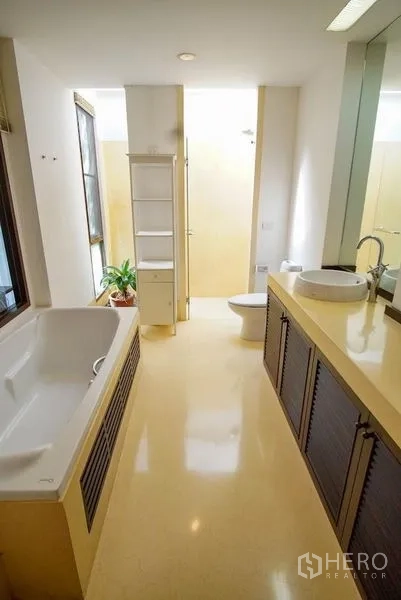 Townhouse for rent in Watthana, Bangkok - Large bathroom with soaking tub, long vanity, and abundant natural light.