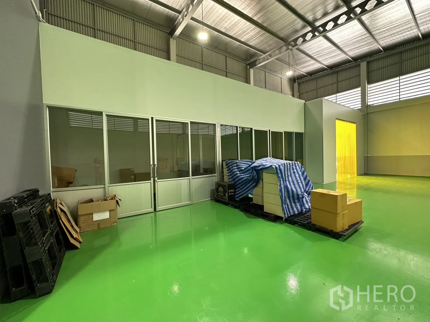 Factory for sale in Lam Luk Ka, Pathum Thani - Warehouse floor with internal office and pallets under steel trusses.