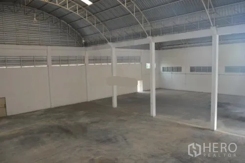 货栈 出租在Samut Sakhon - 从夹层俯瞰大面积仓库地面与钢桁架屋顶。
