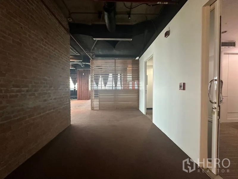 Office Space for rent in Khlong Toei, Bangkok - Reception lounge with exposed ceiling, brick wall and wooden slat divider.