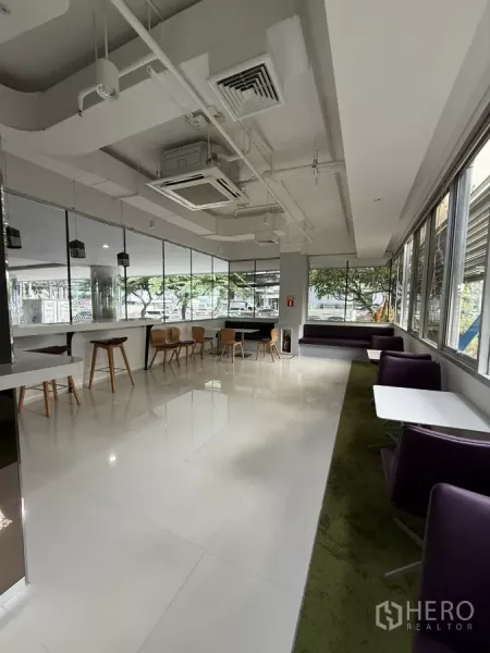 Retail Space for rent in Bang Rak, Bangkok - Corner lounge seating and café tables along large windows with high ceiling and cassette AC.