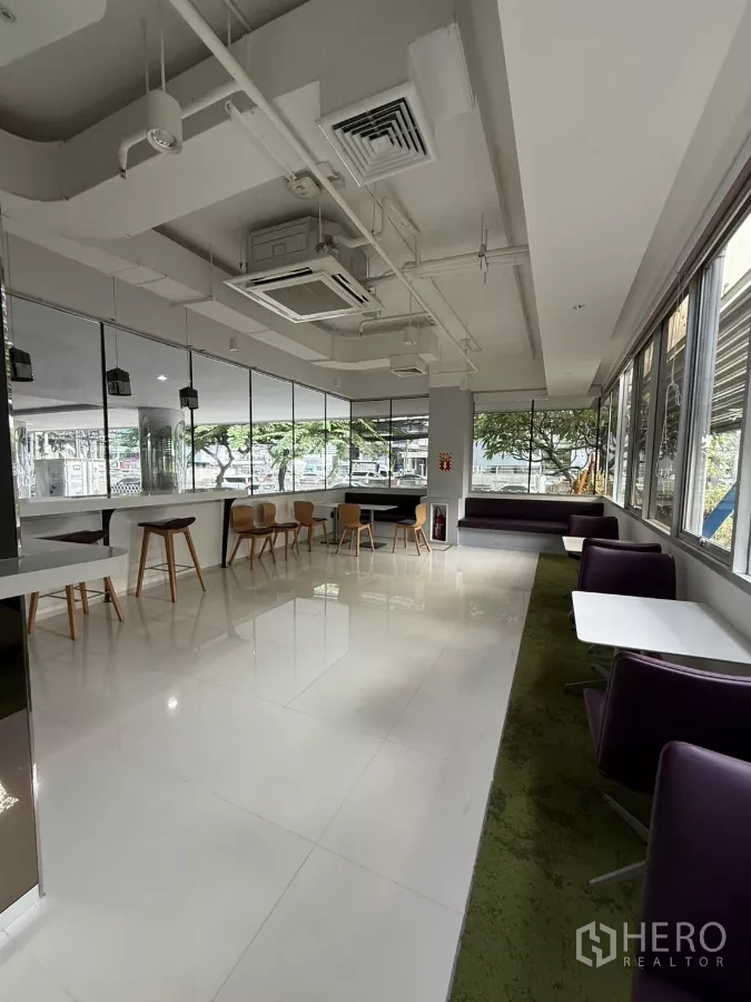 Retail Space for rent in Bang Rak, Bangkok - Corner lounge seating and café tables along large windows with high ceiling and cassette AC.