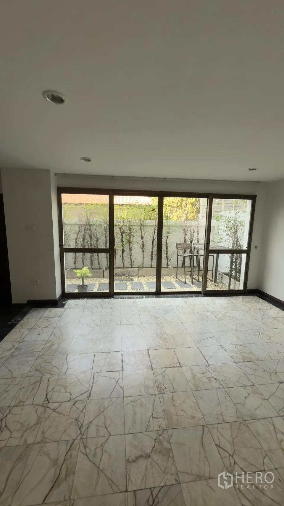 Townhouse for rent in Watthana, Bangkok - View of a small private courtyard through full-height sliding glass doors.